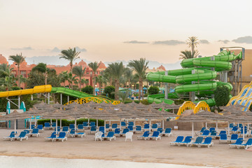 Umbrellas and chaise lounges on the beach. Scenic view of private sandy beach with sun beds from the sea