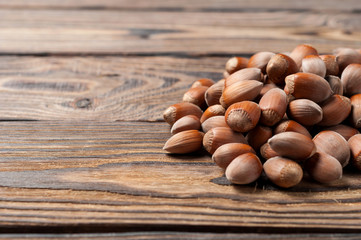 Heap of fresh ripe hazelnuts on old weathered wooden table in kitchen