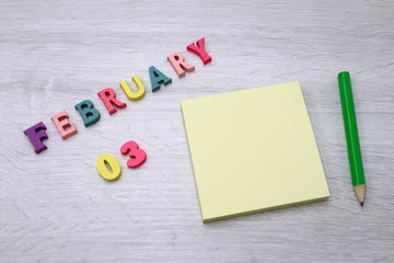 February 3 - Daily colorful Calendar with Block Notes and Pencil on wood table background, empty space for your text or design