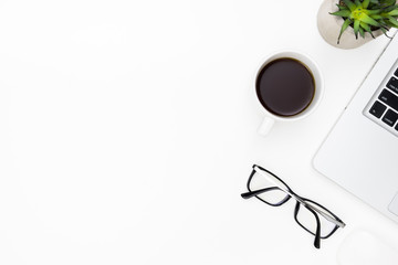 White office desk table with laptop computer, cup of coffee and eye glasses. Top view with copy space, flat lay.