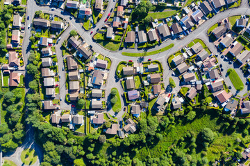 Aerial drone view of small winding sreets and roads in a residential area of a small town - obrazy, fototapety, plakaty