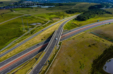 Aerial drone view of a large, new dual carriageway road with motion blurred vehicles (A465, Wales, UK)