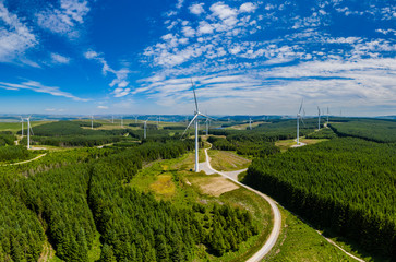 Aerial drone panorama of turbines at a large onshore windfarm in Wales, UK