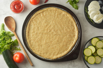 Composition with raw dought and fresh ingredients for pizza isolated on white background. Copy space. Flat lay food ingredients.