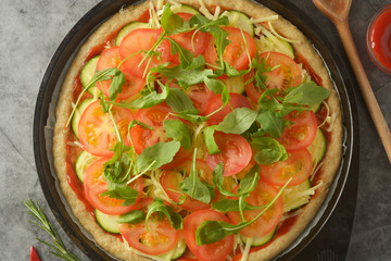 Vegetarian pizza made with wholegrain dough, with zuchinni, tomatoes and mozarella cheese. Healthy, dietical pizza. Top view.