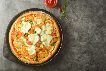 Vegetarian pizza made with wholegrain dough, with zuchinni, tomatoes and mozarella cheese. Healthy, dietical pizza. Top view.