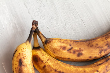 spoiled tainted bananas on grey background. Ugly food trendy photo. Food waste, food garbage