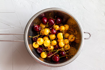 red and yellow cherry berries and peaches mixed at one plate, summer fresh healthy food, picture with space for text 
