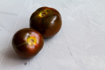 Black delicious tomatoes isolated on grey background. Healthy food