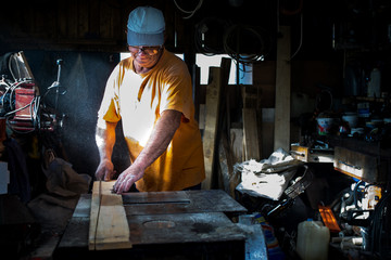 Carpenter cutting wood in workshop