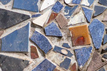 Künstlerisches Mosaik aus blauen, weißen und anderen kleinen Mosaiksteinchen und Kacheln ergeben...