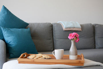 Cozy mornings. Breakfast in the living room. Coffee or tea with cookies on a wooden tray with pink...