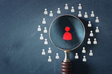 business image of magnifying glass with people icon over chalkboard background, building a strong...