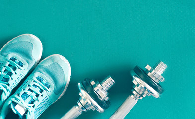 In turquoise color set for fitness, women's sneakers and heavy dumbbells, copy space for text....