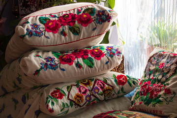 Fototapeta na wymiar An ancient iron bed with embroidered cushions.Old Iron Bed with pillows.Embroidered pillows on an old bed