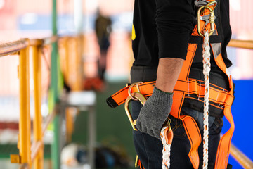 Construction worker use safety harness and safety line working on a new construction site project.