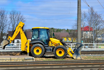 Yellow bulldozer carries out excavation work during the construction and reconstruction of rails and tracks on the railway