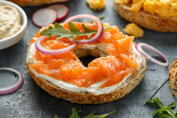 Healthy Bagels breakfast sandwich with Cream cheese and salmon on wooden table..