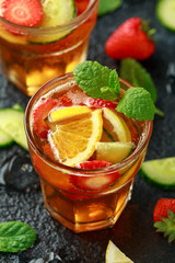 Refreshing Pimms Cocktail with Fruit and vegetables on rustic black table