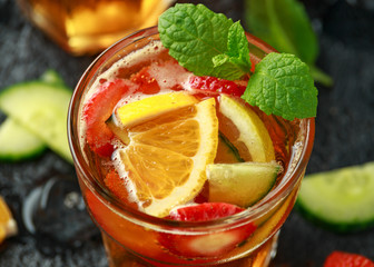 Refreshing Pimms Cocktail with Fruit and vegetables on rustic black table