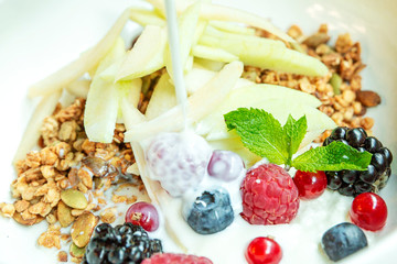 Muesli with fresh berries and fruits in a bowl. Close-up. Delicious and healthy breakfast.