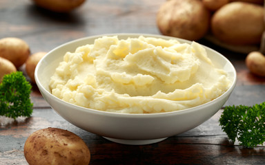Mashed potatoes in white bowl on wooden rustic table. Healthy food - obrazy, fototapety, plakaty