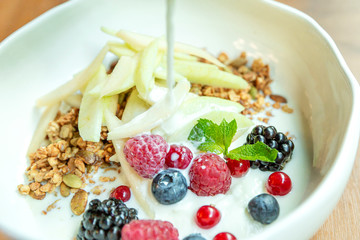 Muesli with fresh berries and fruits in a bowl. Close-up. Delicious and healthy breakfast.