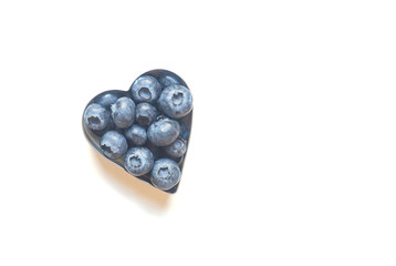 Blueberries in the shape of heart isolated on white background.