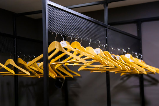 bright wooden hangers with numbers in empty cloakroom or checkroom or wardrobe
