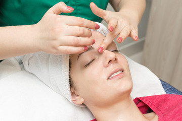 Face skin care. Beautician applying beauty oil mask on face using brush In spa salon	