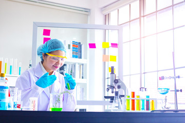 Fototapeta premium Young Asia woman scientist working in laboratory.She is smell test with red and blue test tube.trying,research Experiment,chemical Photo concept develop and medicine.