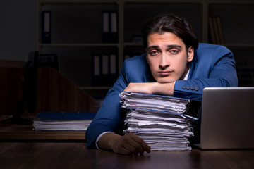 Fototapeta premium Young male employee working night in the office 