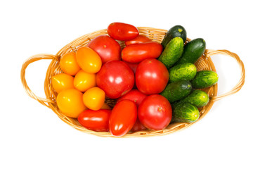 fresh tomatoes and cucumbers in basket isolated on white background