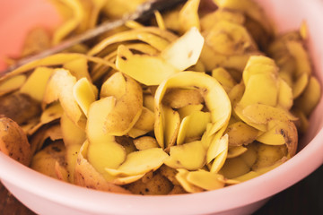 Potatoes Peels in bowl with knife used to prepare fries
