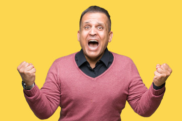Fototapeta premium Middle age arab man over isolated background celebrating surprised and amazed for success with arms raised and open eyes. Winner concept.
