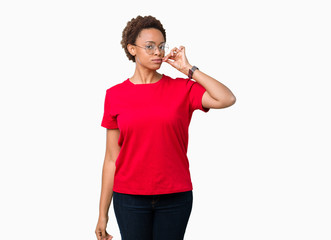 Beautiful young african american woman wearing glasses over isolated background mouth and lips shut...