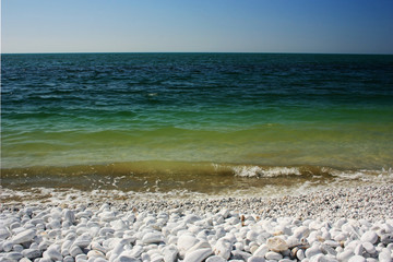 Fototapeta na wymiar Green waves of the sea lapping on the shore