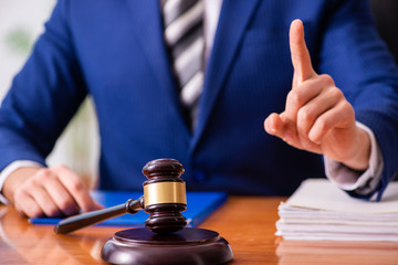 Young male judge sitting in courtroom 