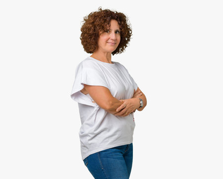 Beautiful middle ager senior woman wearing white t-shirt over isolated background Relaxed with serious expression on face. Simple and natural with crossed arms