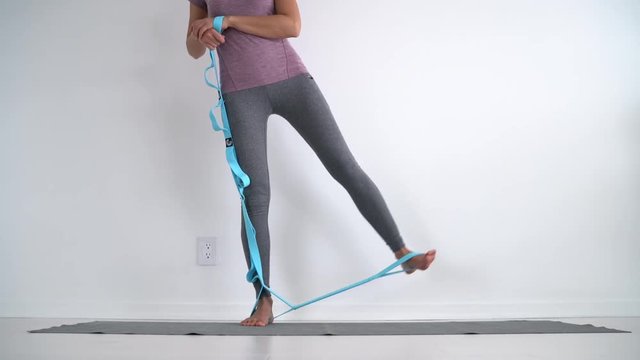 Resistance band fitness girl doing standing side lateral leg raise for hip abductor activation workout exercises with rubber strap elastic. Glute muscle activation training at home
