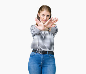 Middle age mature beautiful woman wearing stripes winter sweater over isolated background Rejection expression crossing arms and palms doing negative sign, angry face