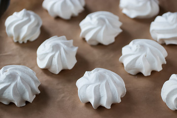 White meringues on brown paper. Preparation for dessert Pavlova.
