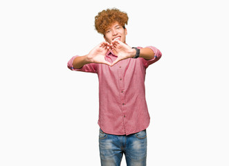 Young handsome business man with afro hair smiling in love showing heart symbol and shape with hands. Romantic concept.