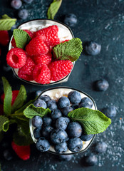 Cottage cheese with cream, raspberry and blueberry garnished with fresh mint.