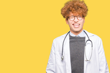Young handsome doctor man wearing medical coat winking looking at the camera with sexy expression,...