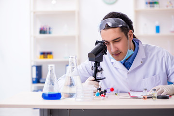 Young male chemist experimenting in lab