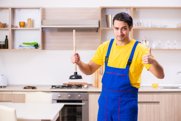 Young male contractor repairing tap at home 