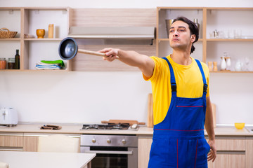 Young male contractor repairing tap at home 
