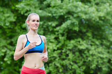 woman is jogging in the park on green background - 277080399
