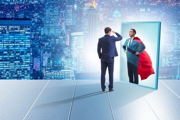 Businessman seeing himself in mirror as superhero